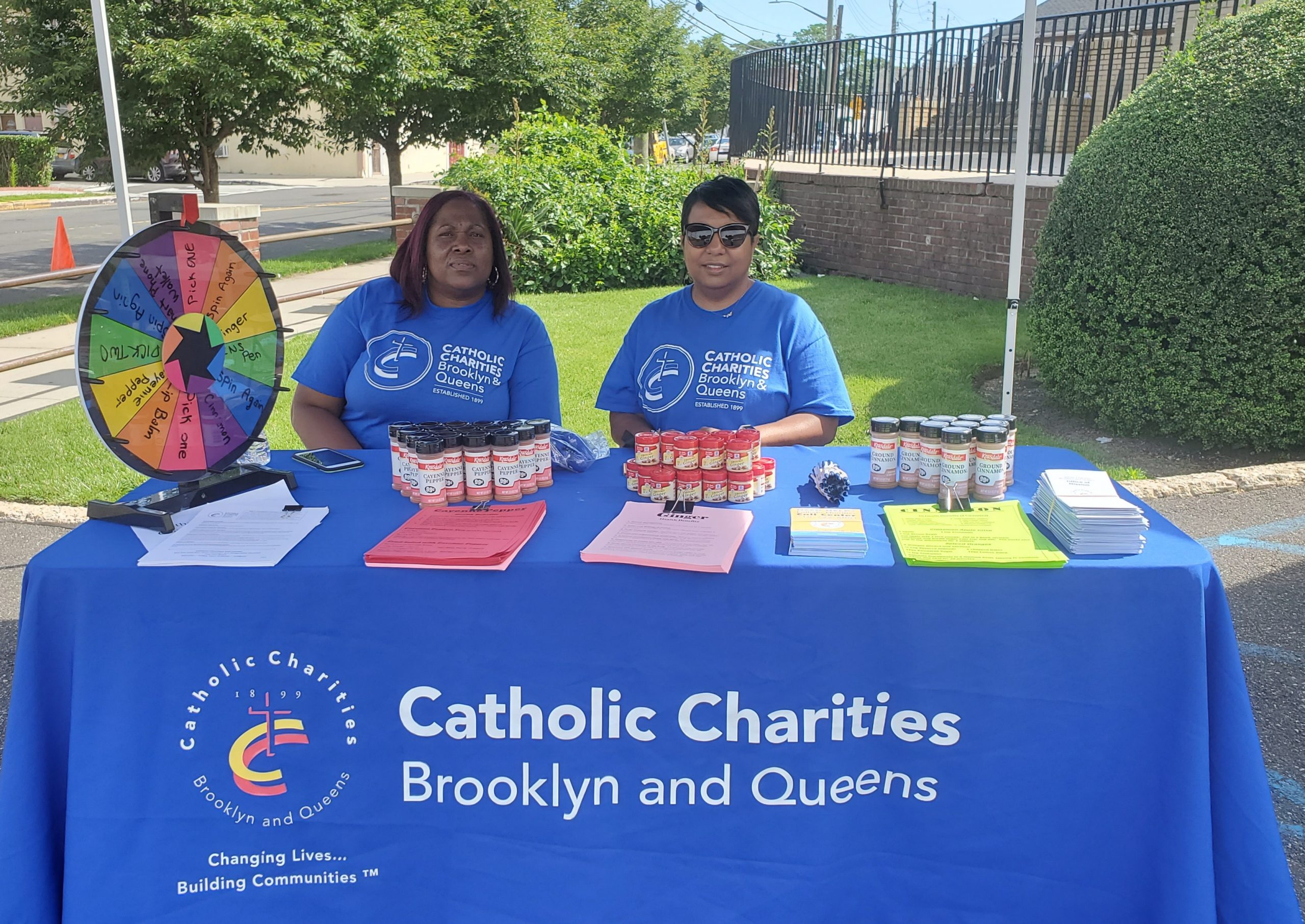 catholic charities participating in the outdoor community health fair distributing samples and information for a Community Fit and Healthy