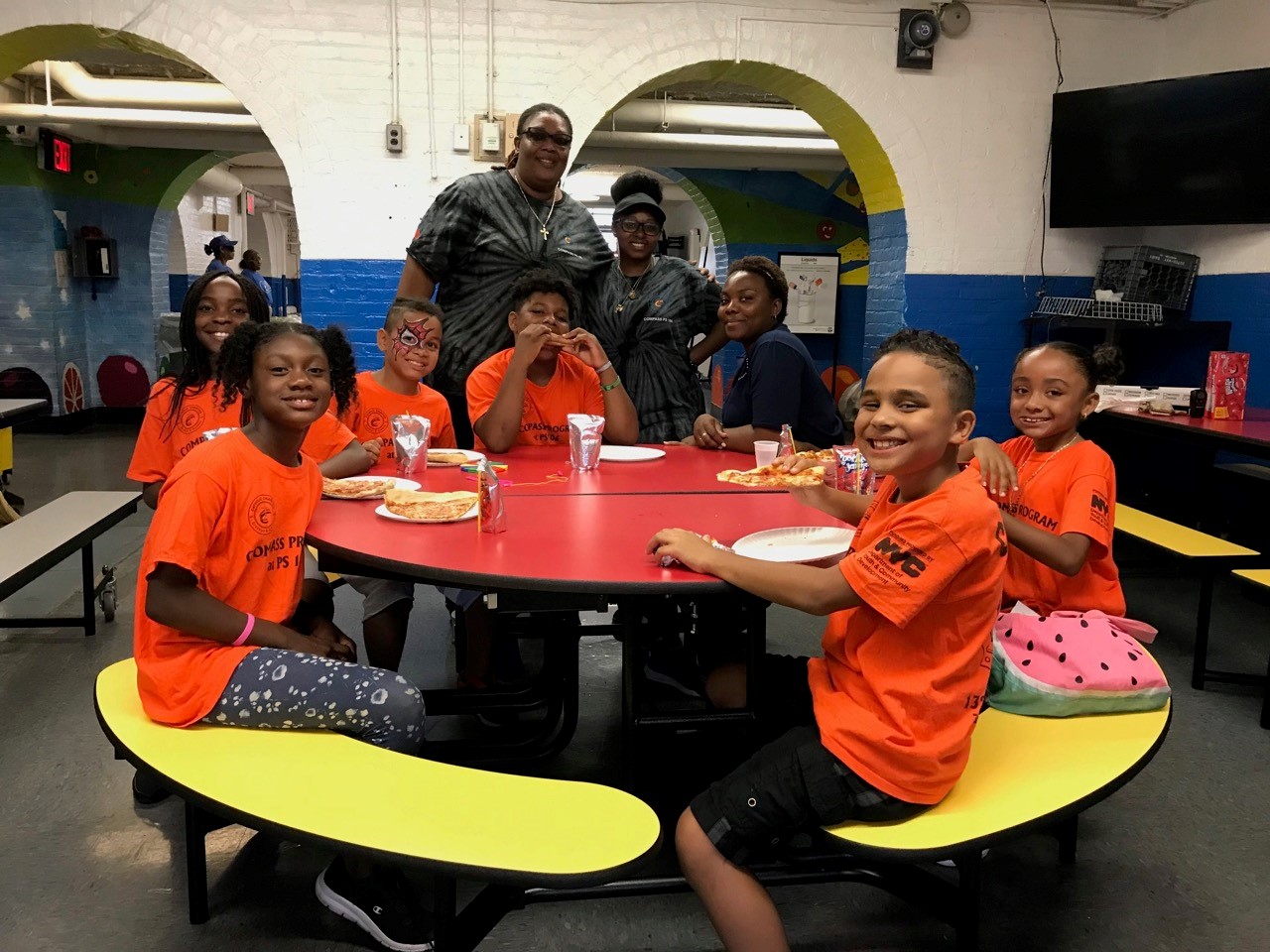 group of children and families eating pizza during the Health, Wellness and Community Day