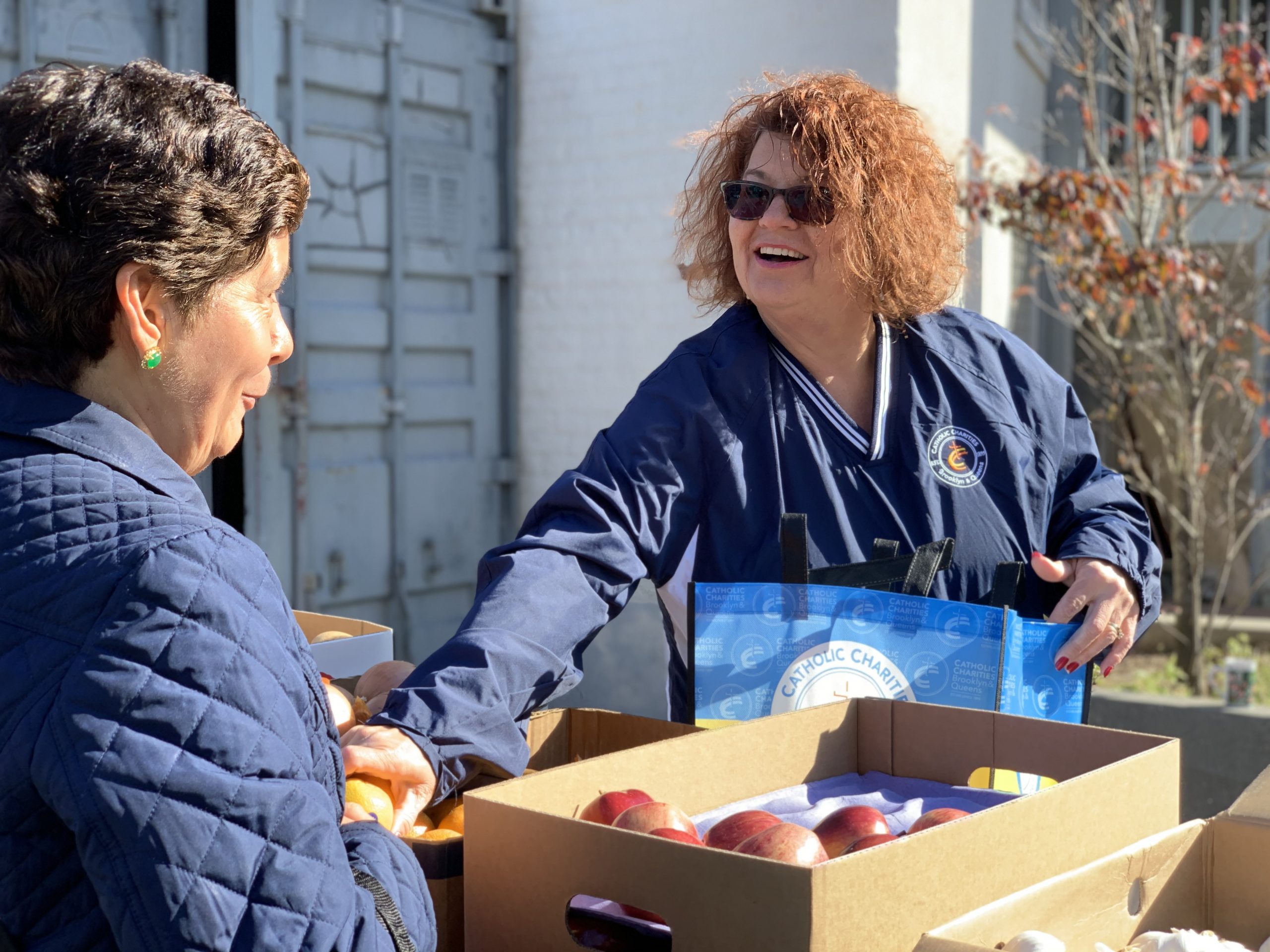 a ccbq staff member giving food to a guest from the mobile services center