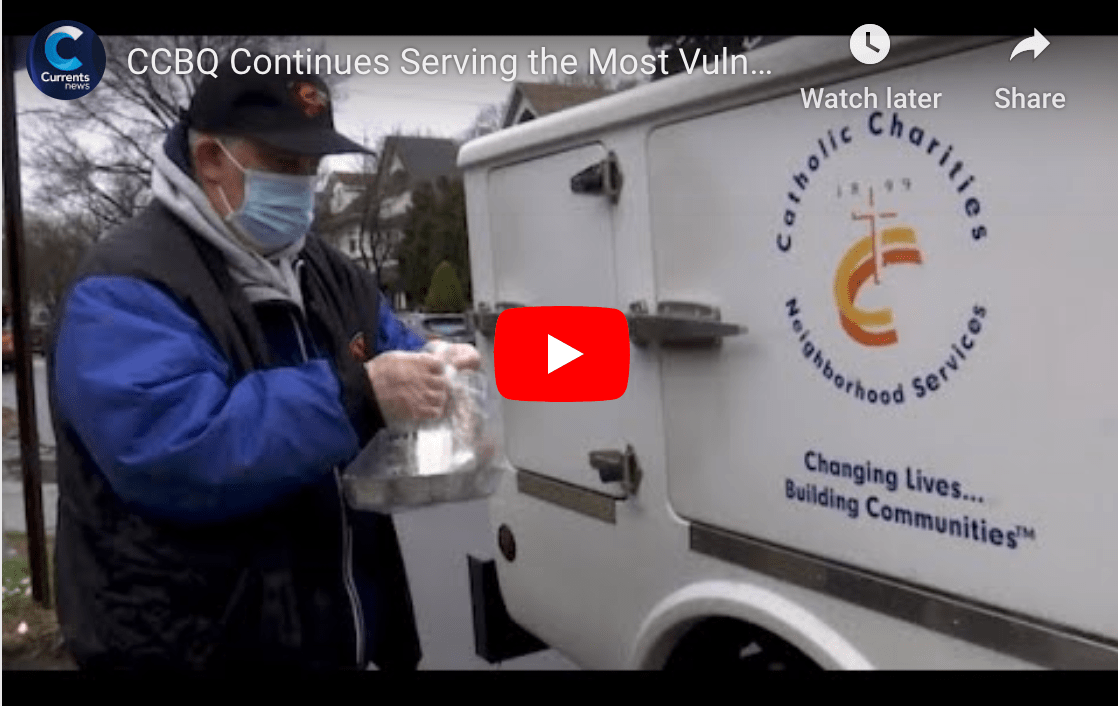 catholic charities is donating food outside with a mobile truck