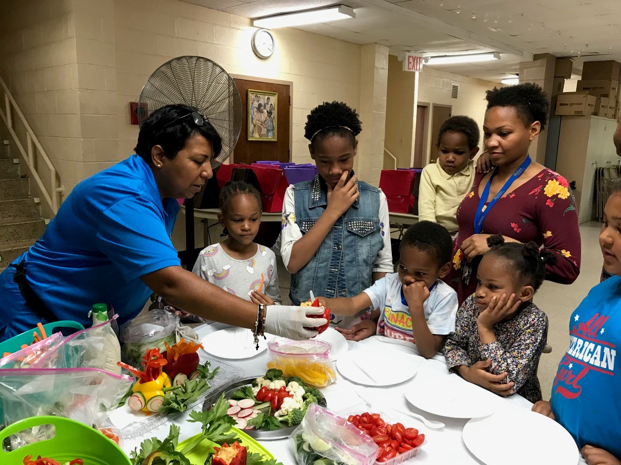 kids and parents around a table during the summer intergenerational barbecue event