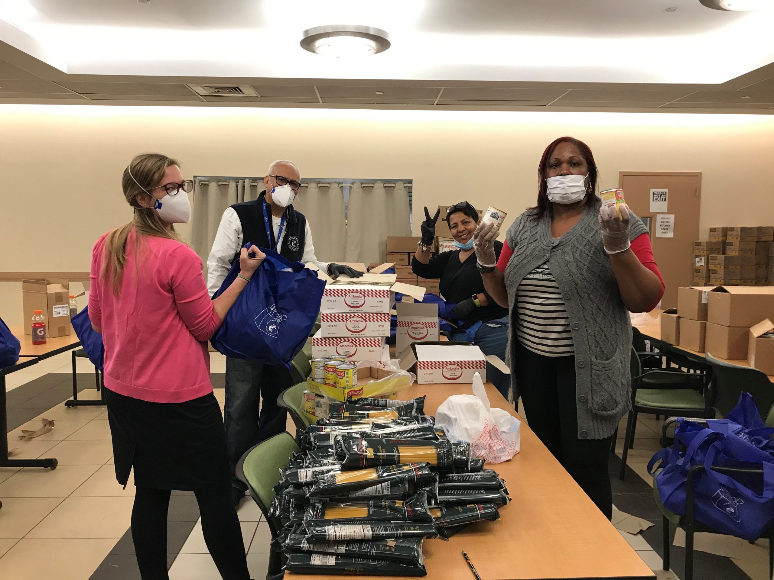 ccbq staff is packing food bags for seniors for Kindness Has No End Date