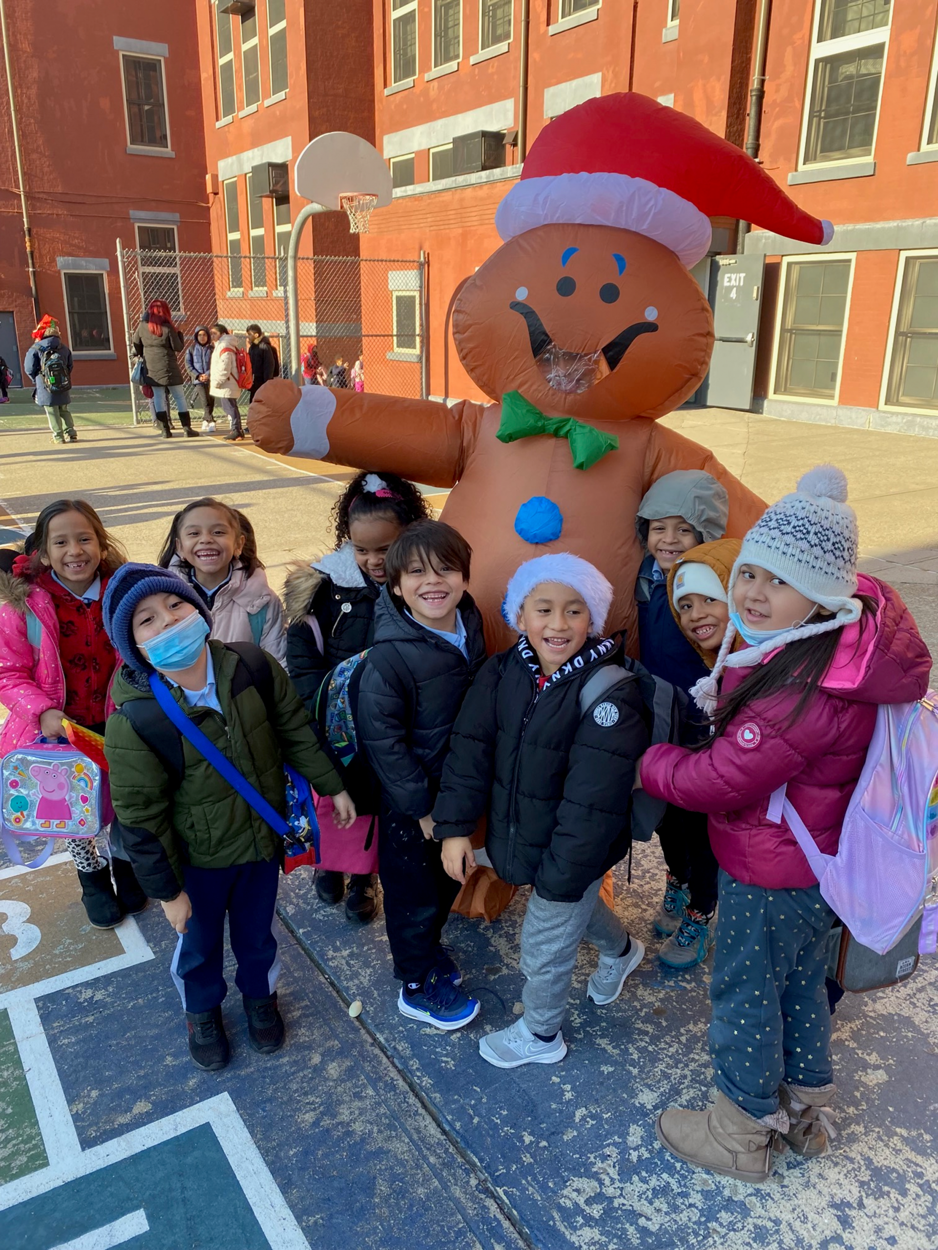 Students of COMPASS PS 106 smile big with Gingerbread Man prop.