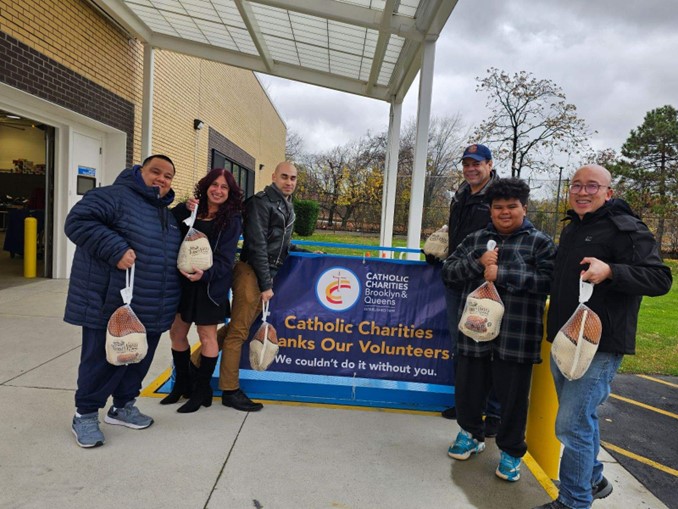 The Turkey Distribution volunteers, staff, and local parish leaders holding a turkey