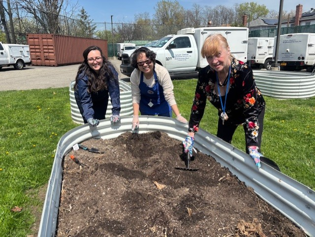 three members at howard beach gardening and celebrating earth day