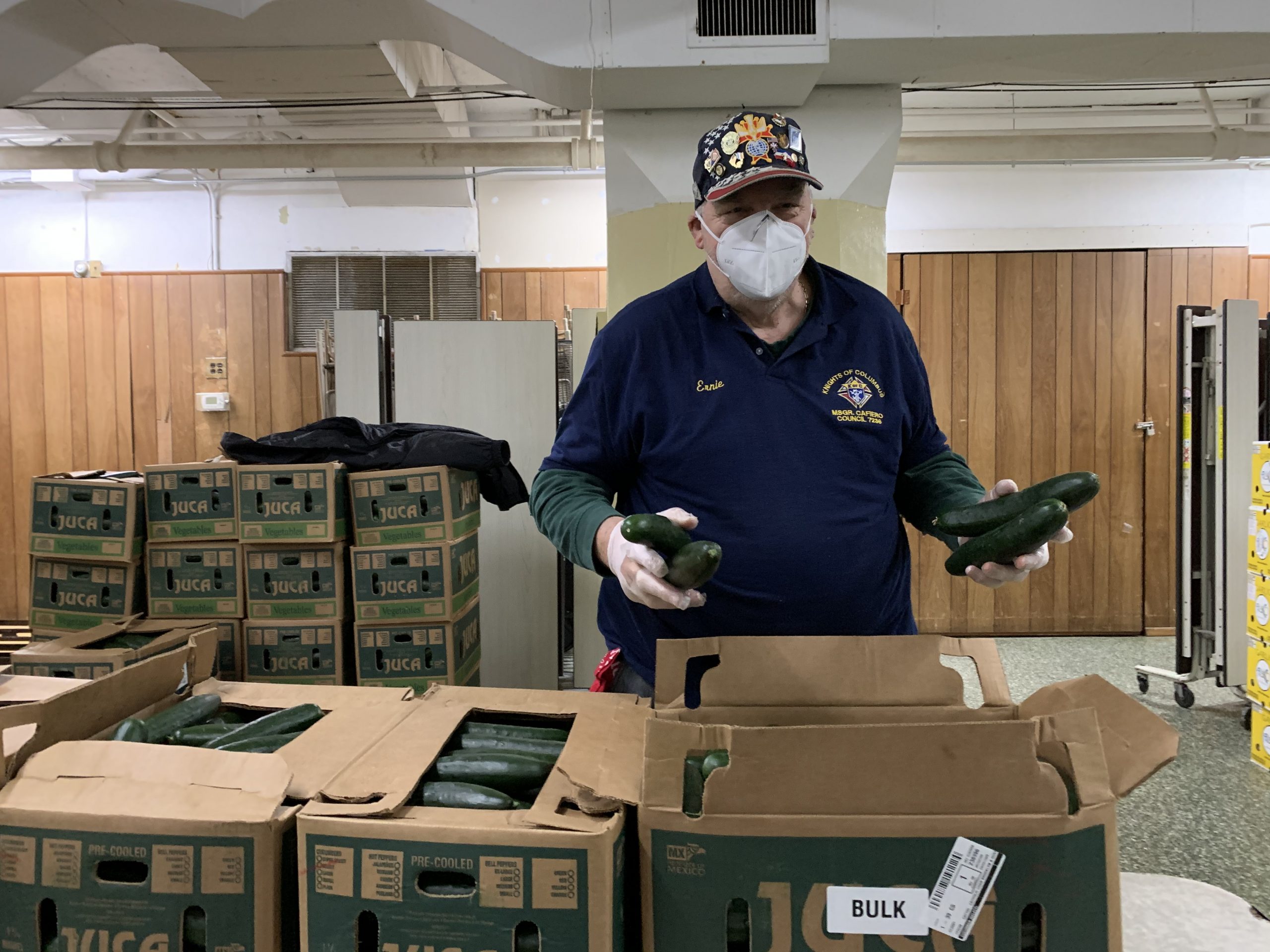 a knight of columbus participant extending a hand to catholic charities distributing food