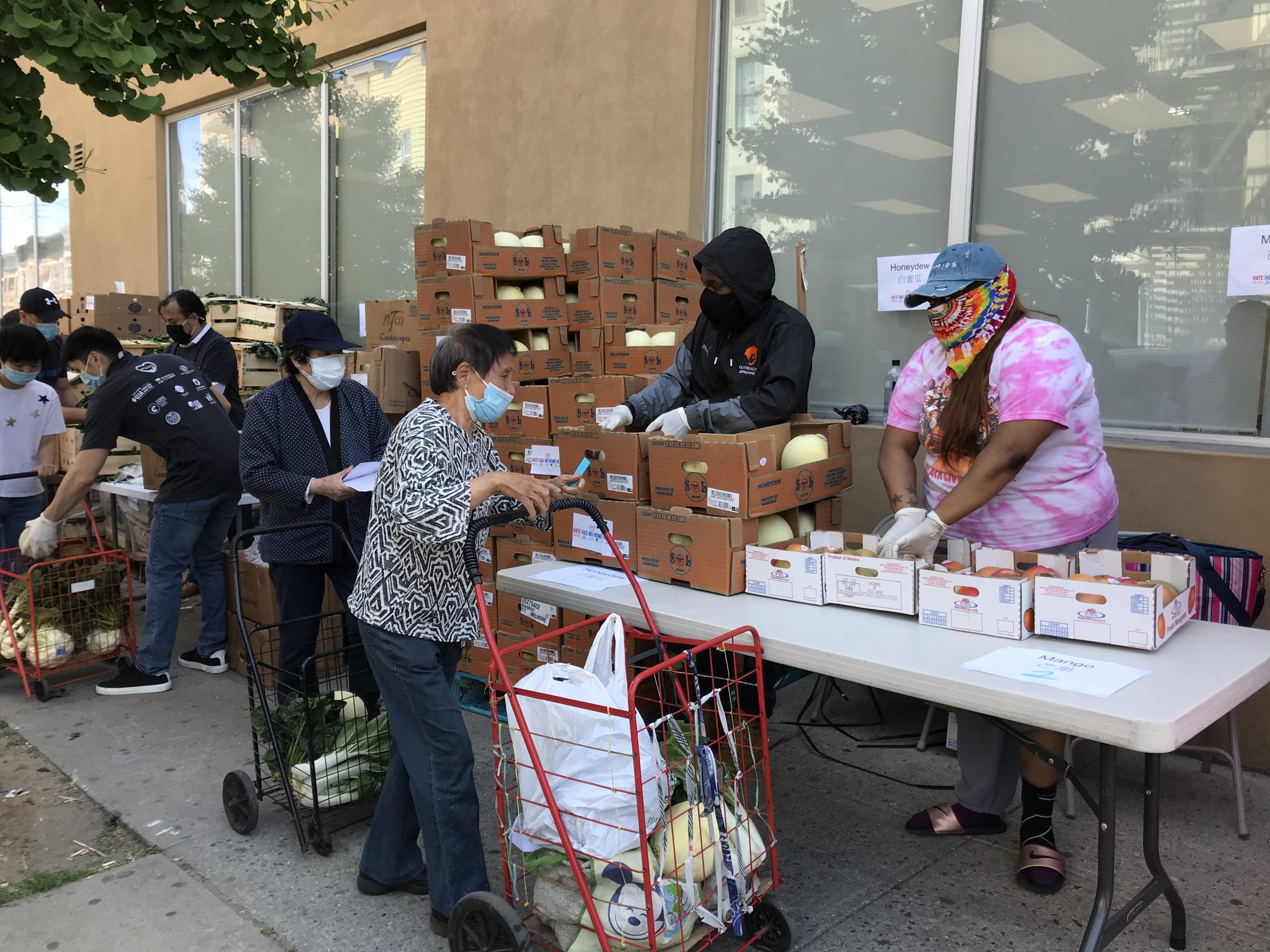 catholic charities of brooklyn and queens staff is distributing food at a food bank event for Feed Hungry and #StopAsianHate