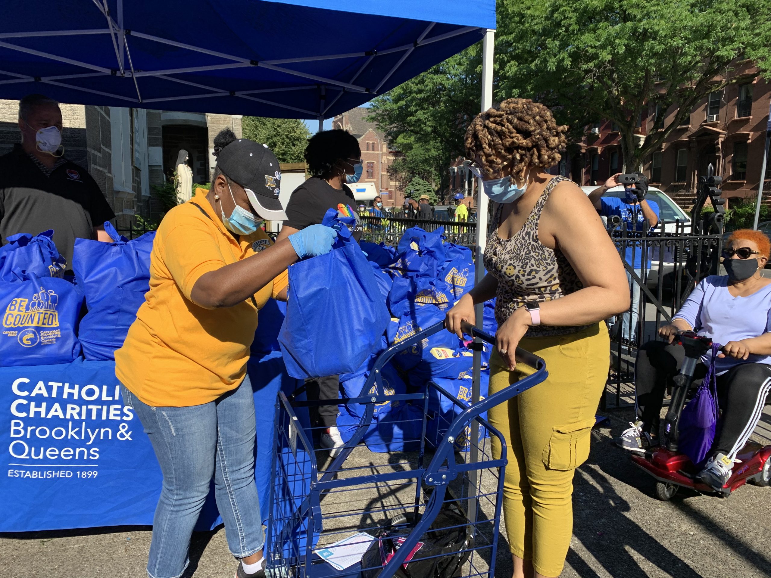 catholic charities staff distributing a food bag to a guest during the emergency pop up event in brooklyn