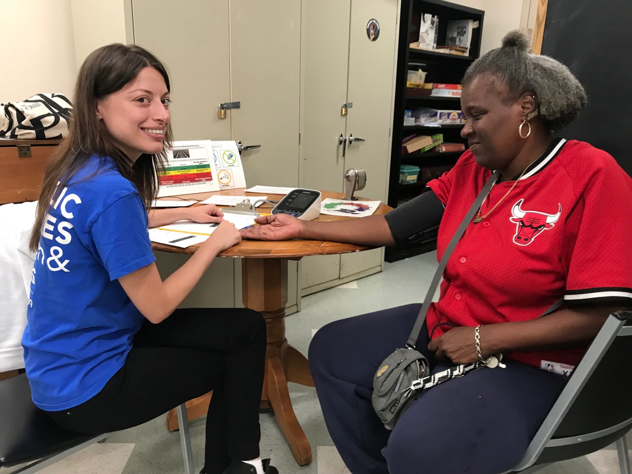 a professional from catholic charities of brooklyn and queens taking care of a woman in need for the Importance of Health and Wellness