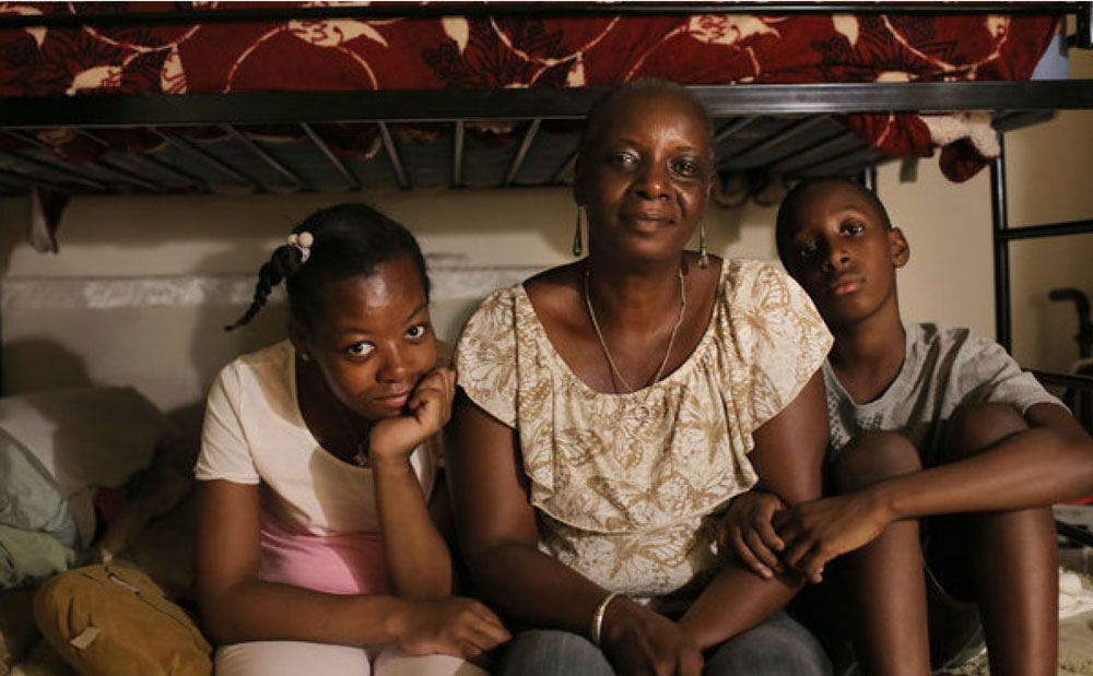 a mother and her 2 children posing for the new york times neediest cases fund