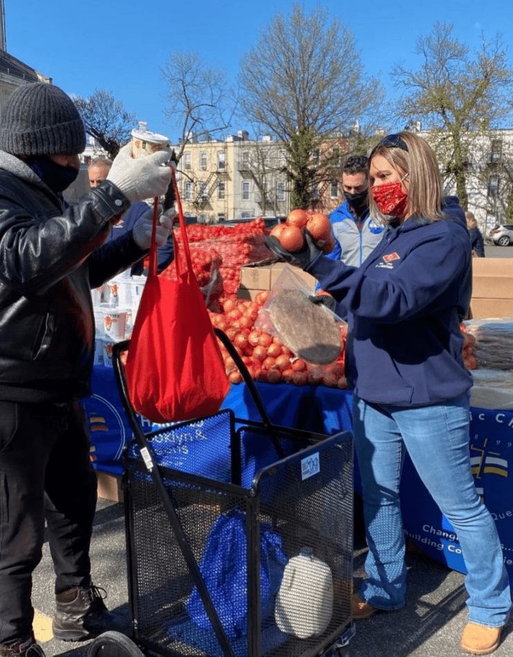 catholic charities staff member distributing meals to a community member
