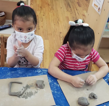 two little girls playing with clay