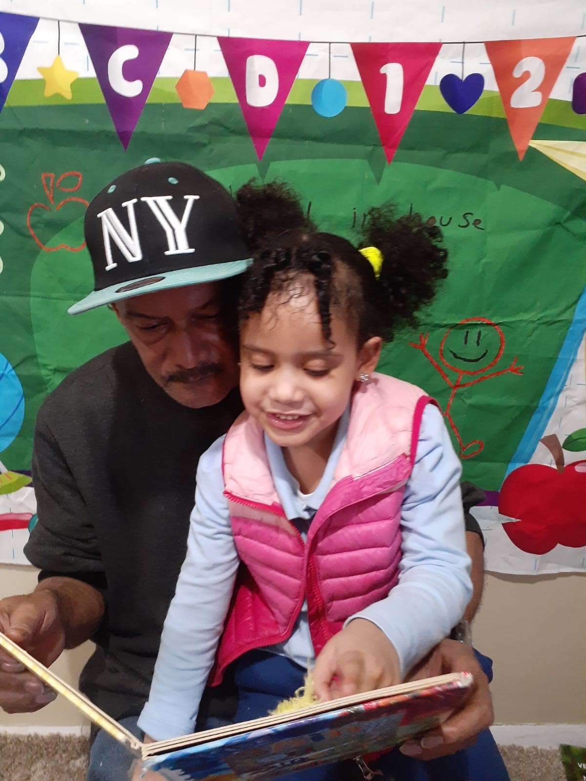 a father reading a book to this daughter