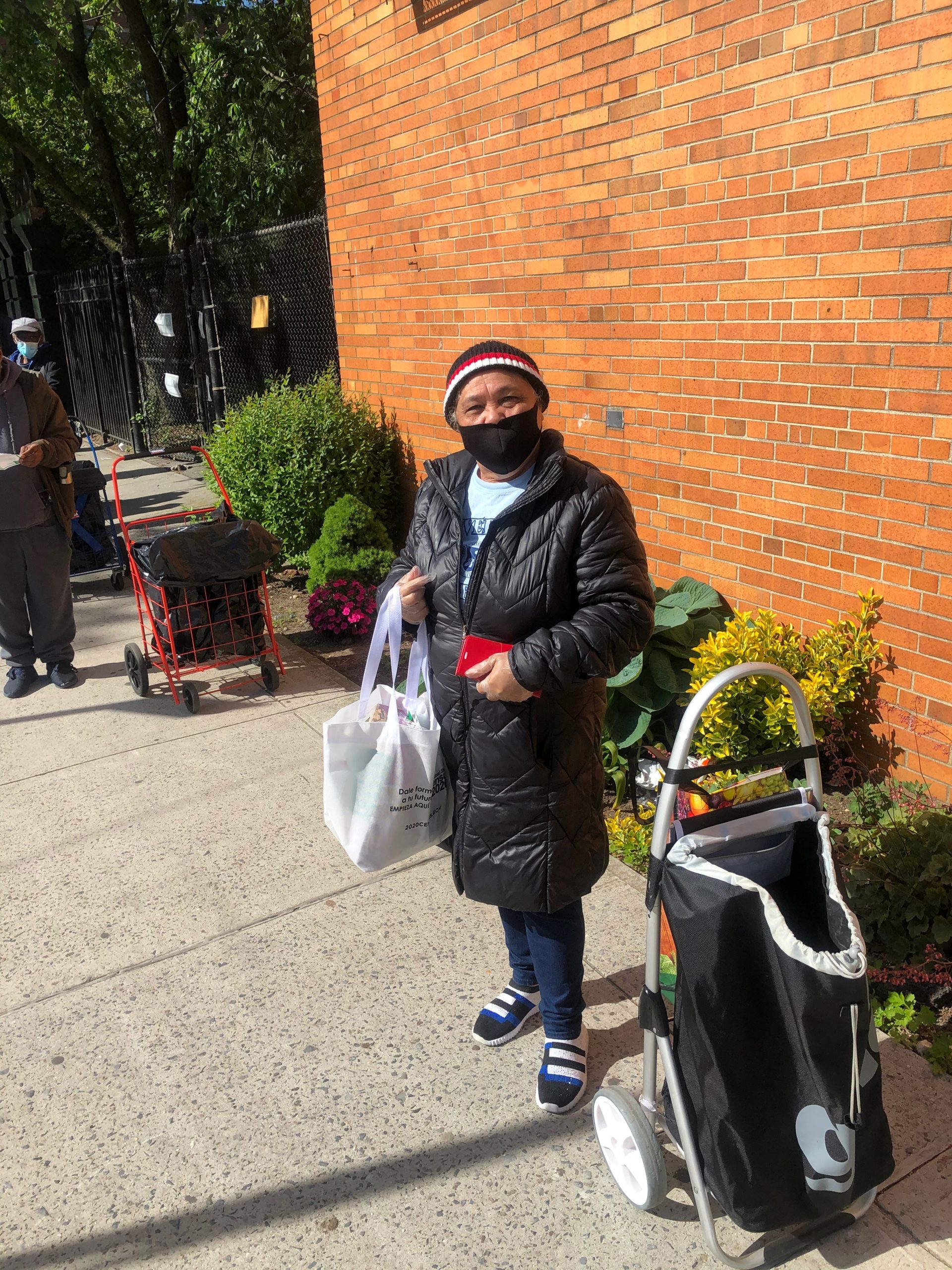 a community member receiving fresh produce and non perishable food at the food pantry