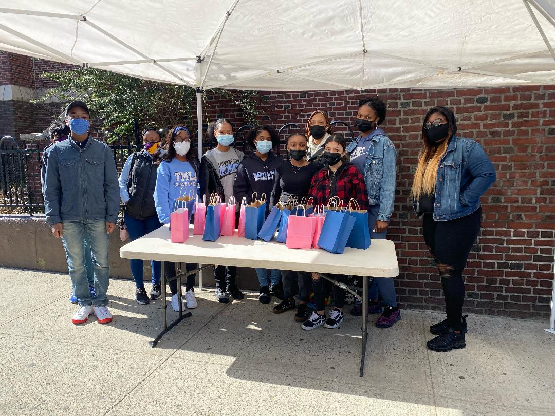 a group of teenagers at a pop-up event with gift bags