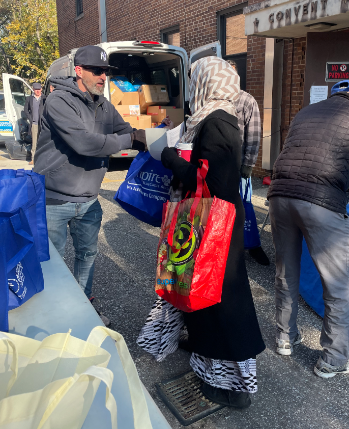 Catholic Charities Brooklyn and Queens distributes Thanksgiving turkey to community member in need.