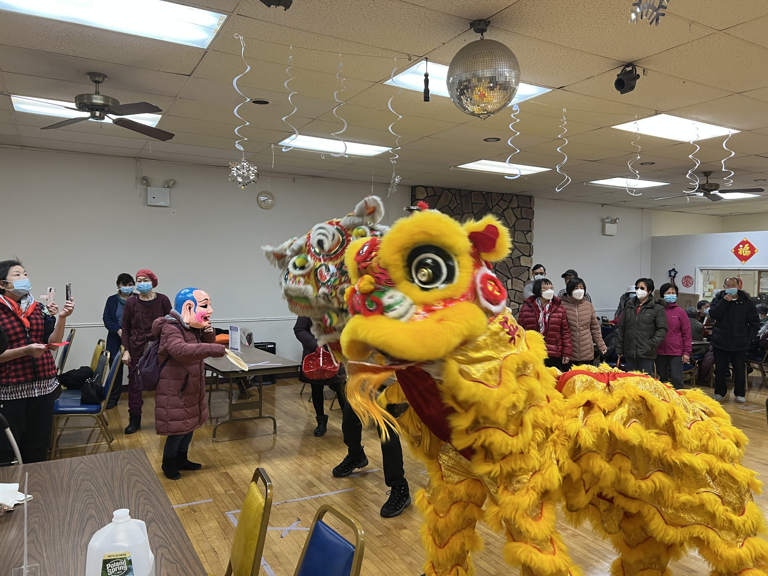 Dancing lion with older adult center members.