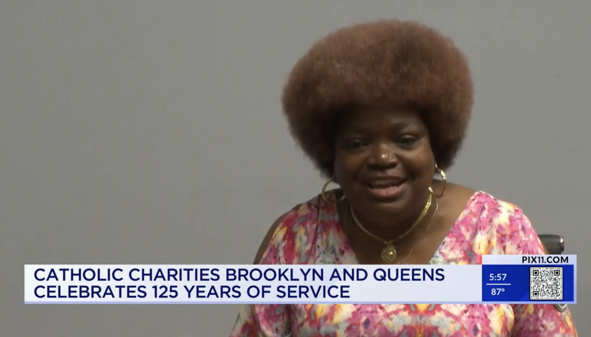 A woman smiling while being interviewed by PIX 11 for 125 Years of Transformative Work by catgolic charities