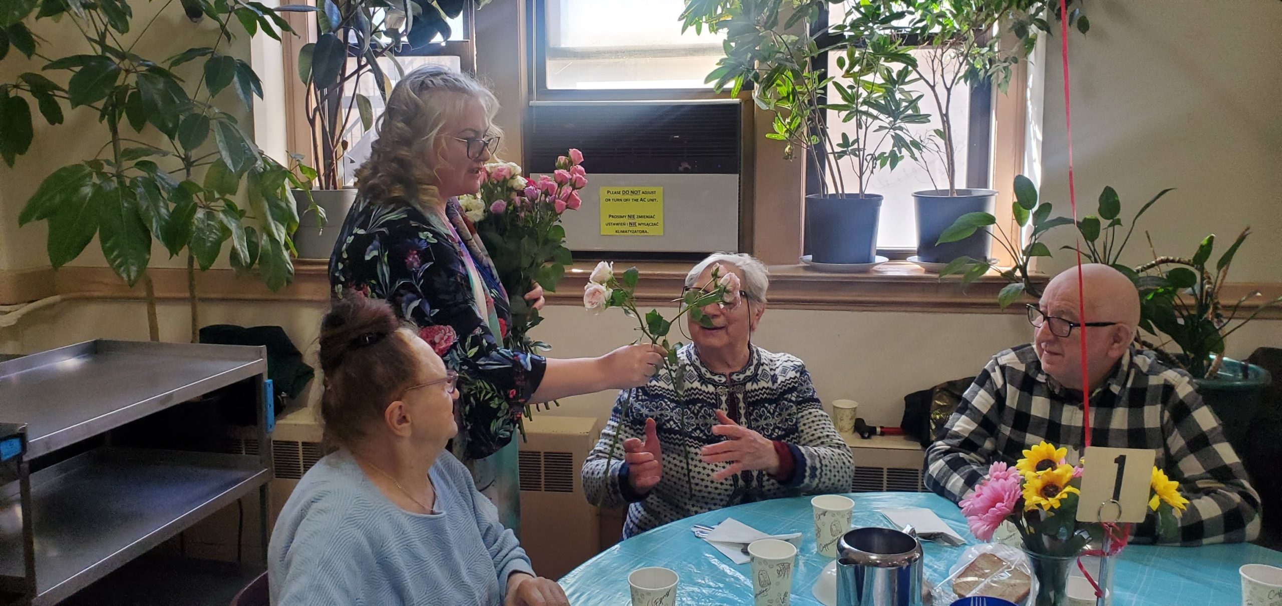 a staff member is giving roses to the women for international women's day