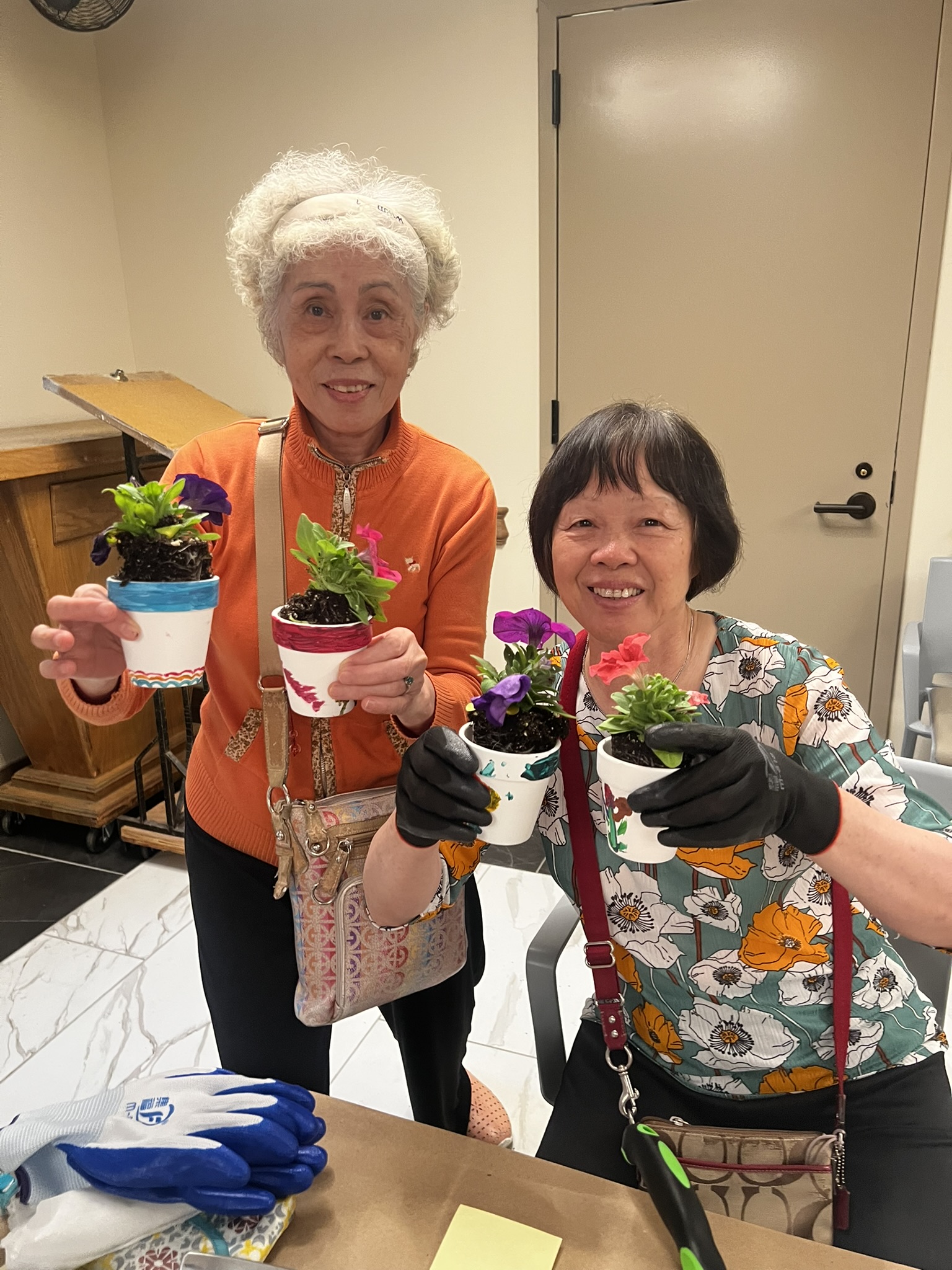 two older adults showing little plants for the gardening activity