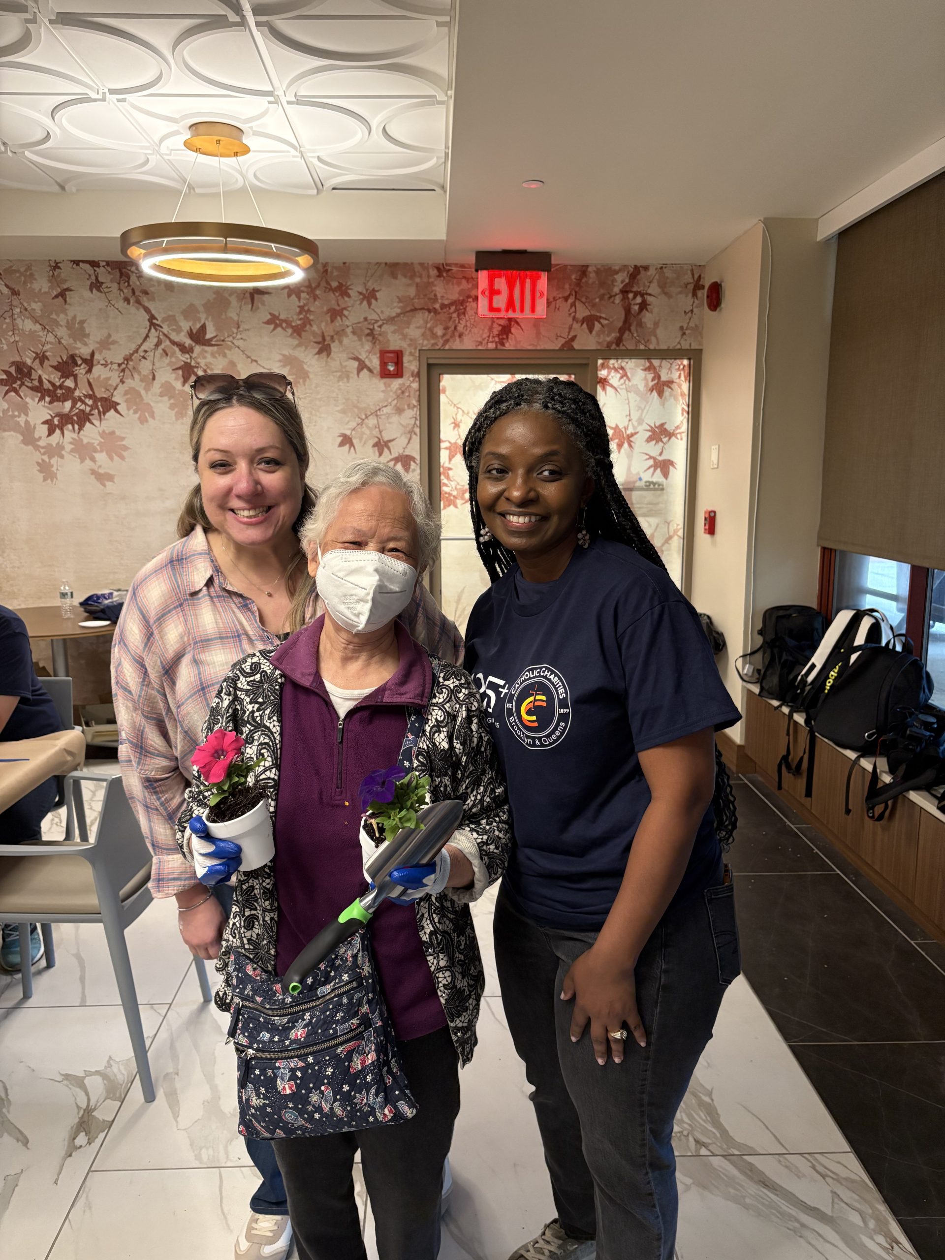two volunteers and a senior adult getting prepared to gardening