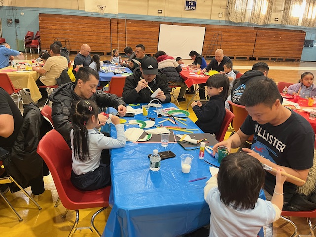 fathers and children crafting together during the spring insect art activities day