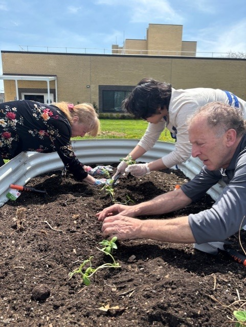 outreach team members gardening for earth day