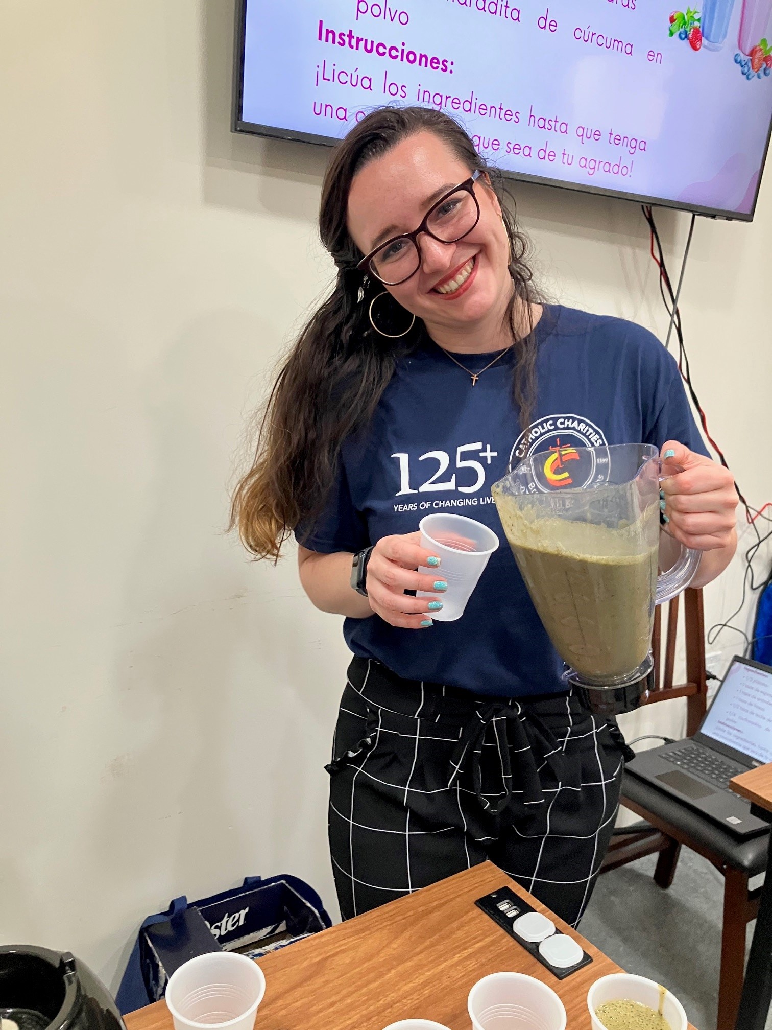 Staff member of the community health and wellness team serving a smoothie at the brain food health workshop