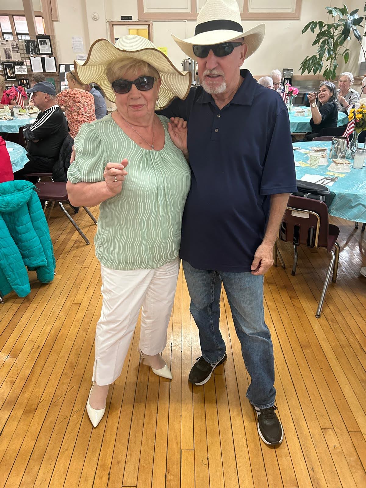 an elderly couple wearing fancy hats at pete mcguinness older adult center