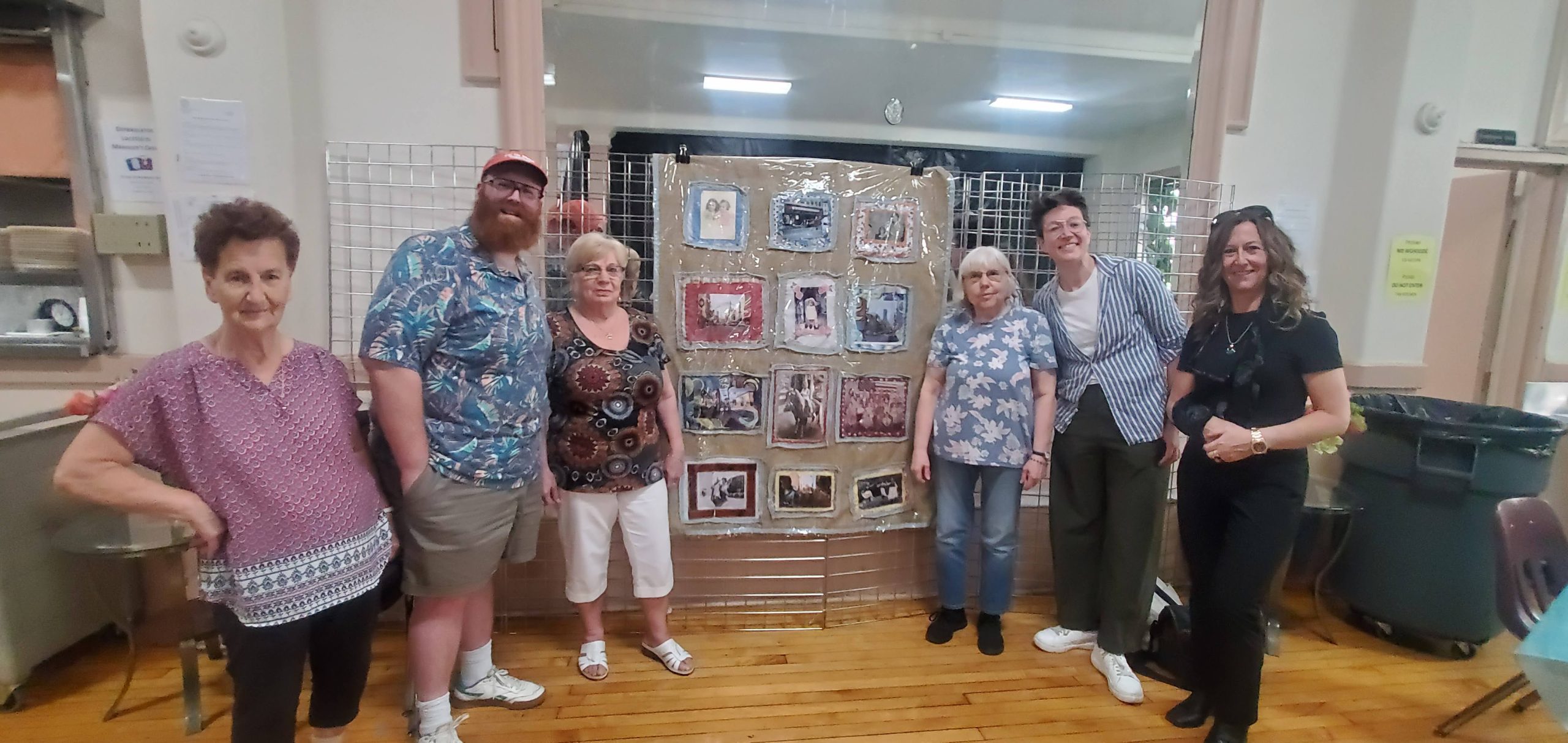 community members gathered in front of the collaborative project called the neighborhood photo quilt