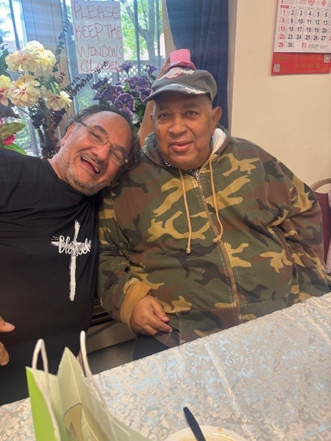 Father and son smiling during Father's day celebration at saint paul the apostle senior apartments