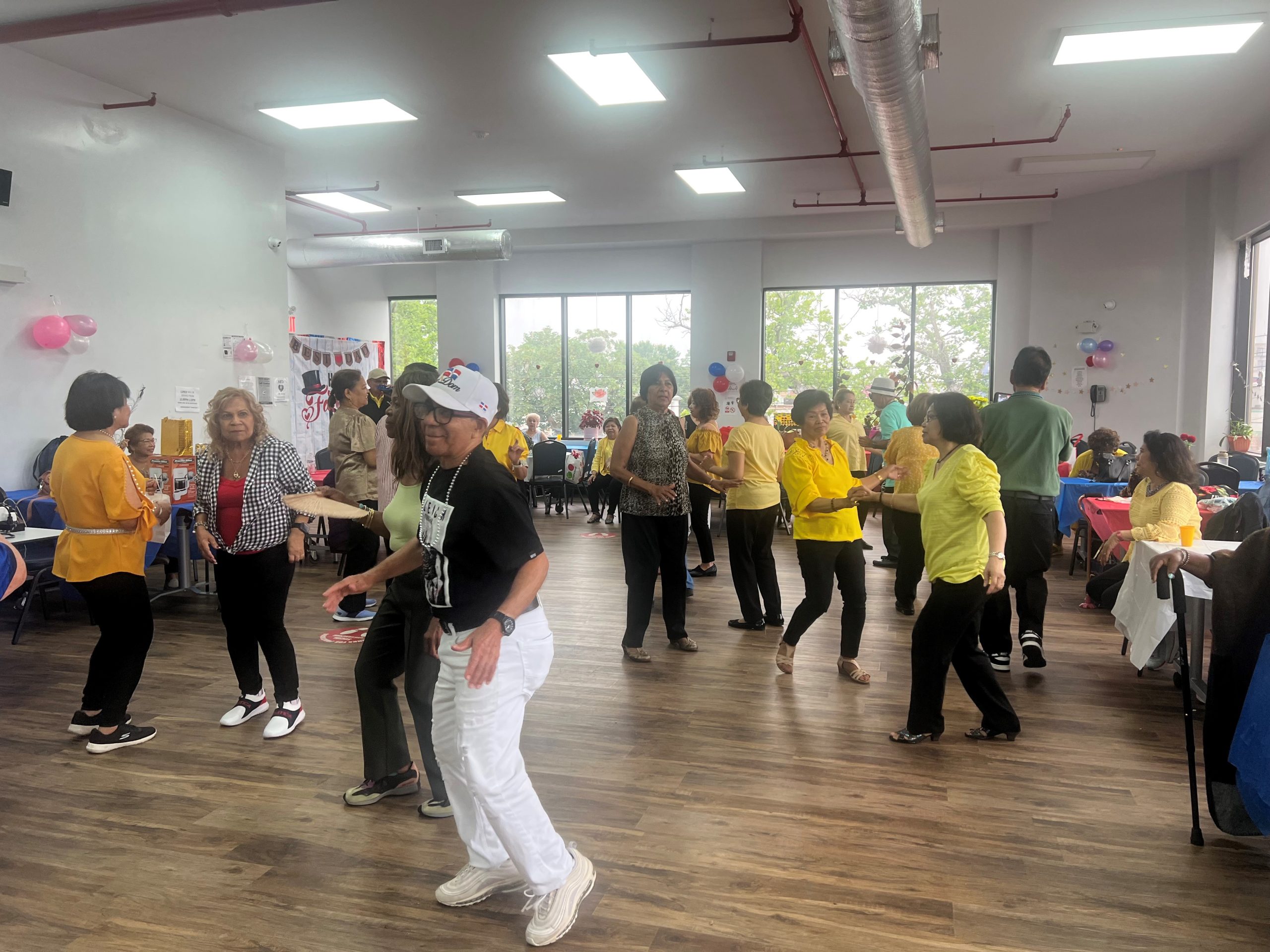 families and friends dancing during father's day at the hillcrest older adult center