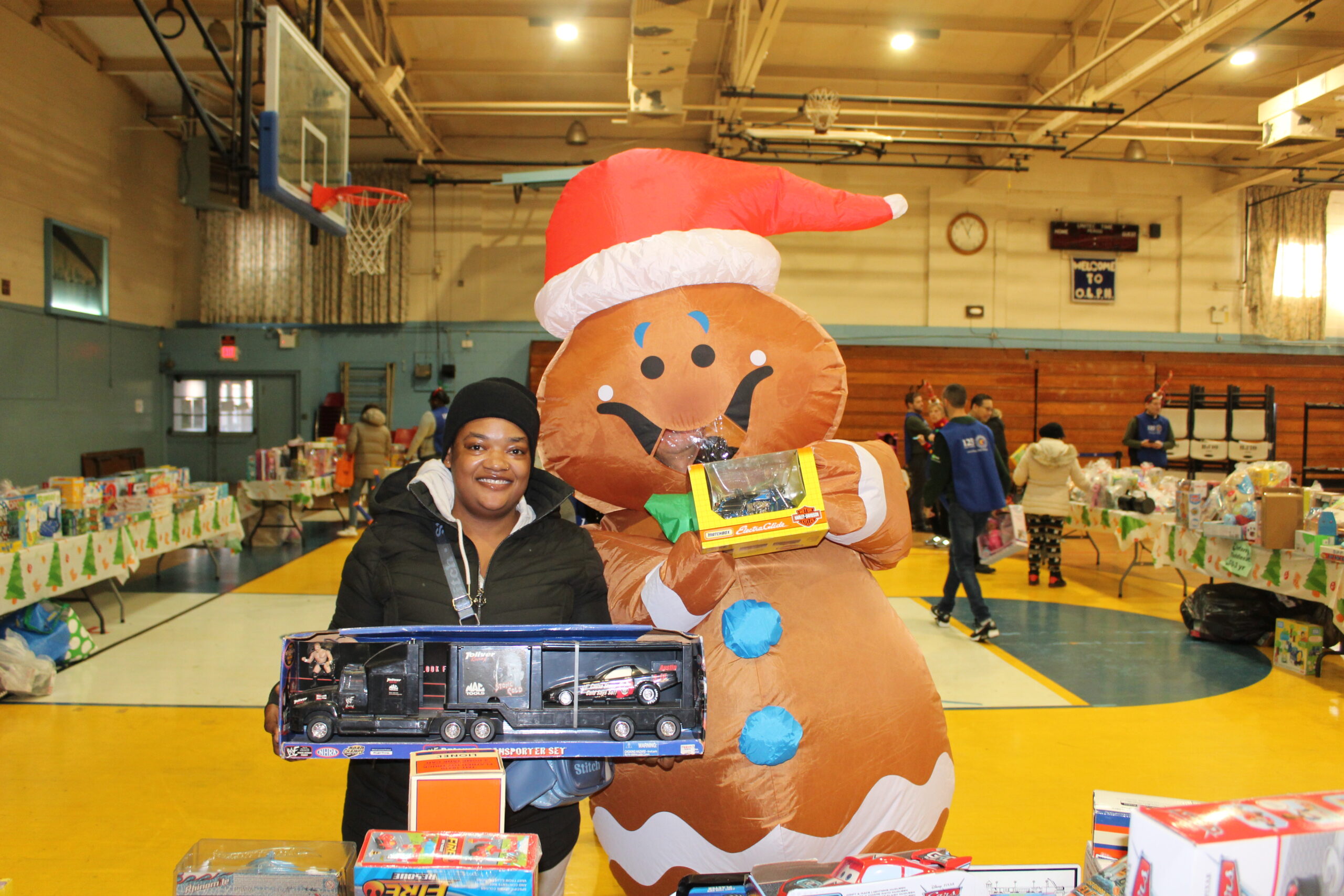 a mother and costumed snow man showing toy's at the annual santa's toy event