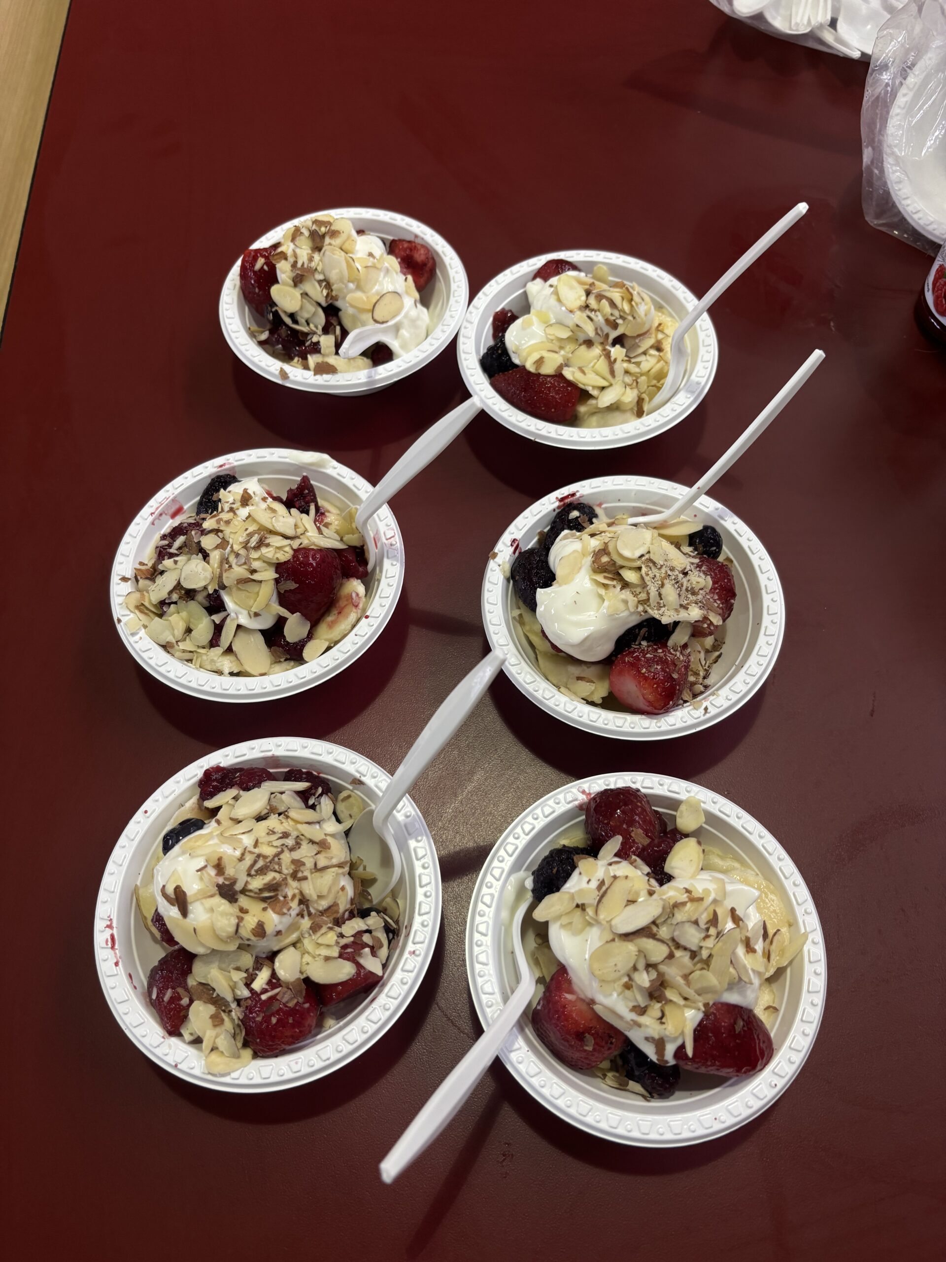 a healthy snack: non-fat Greek yogurt, sliced almonds, low-sugar raspberry jam, frozen berries, and bananas